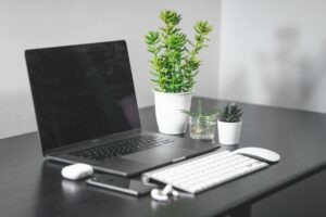 laptop computer beside white apple magic keyboard and magic mouse